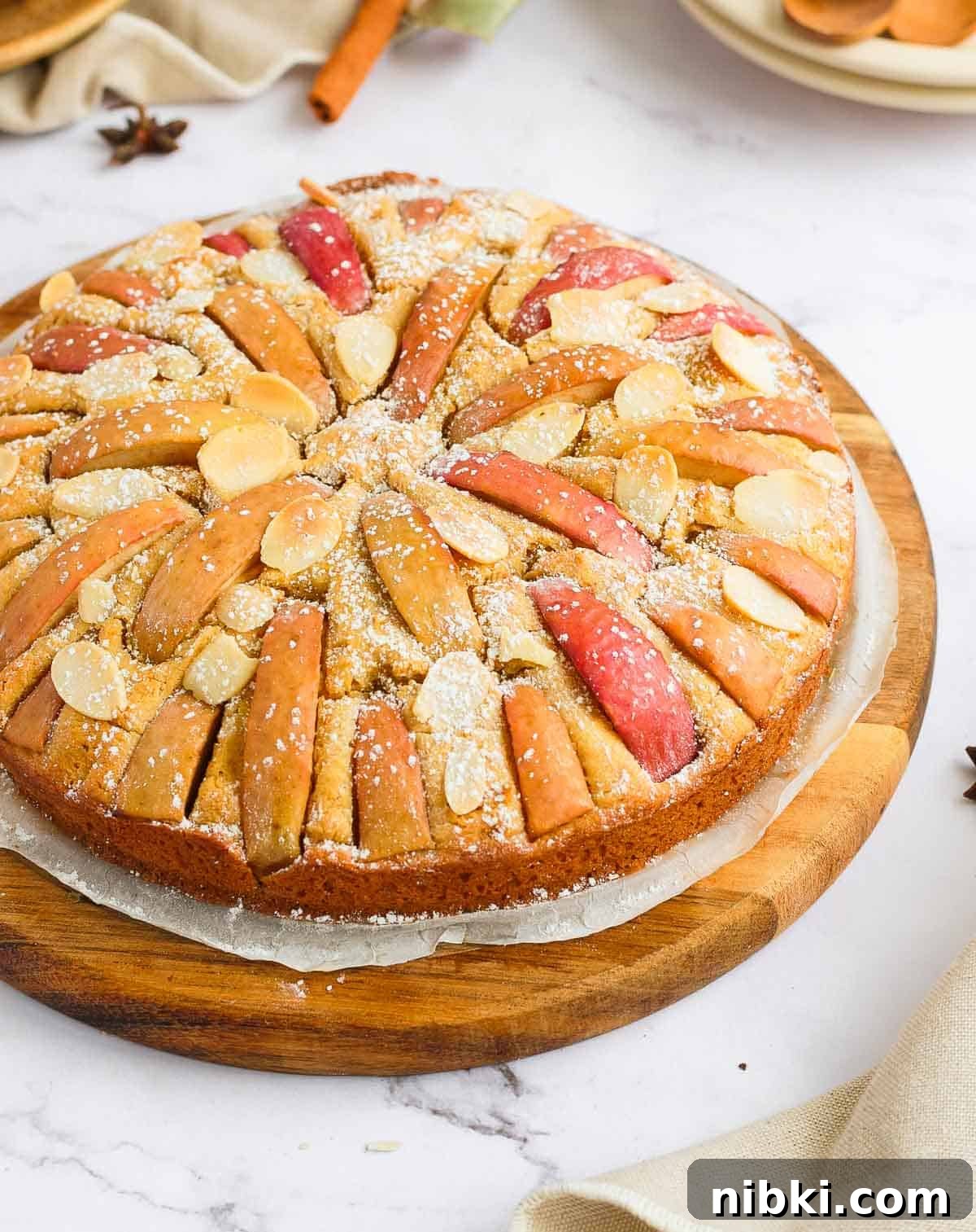 Moist Gluten-Free Apple Cake Recipe 3 Side of the cake sitting on a wooden round board.