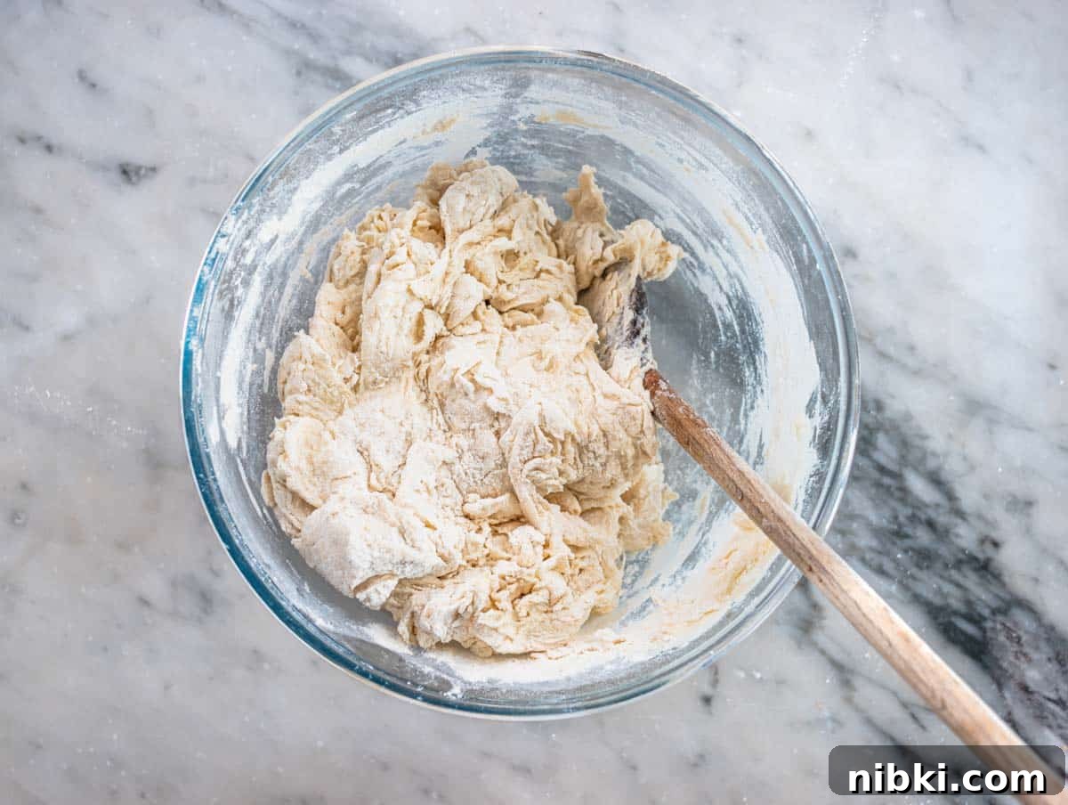 mixing flour, water, and yeast in a large mixing bowl