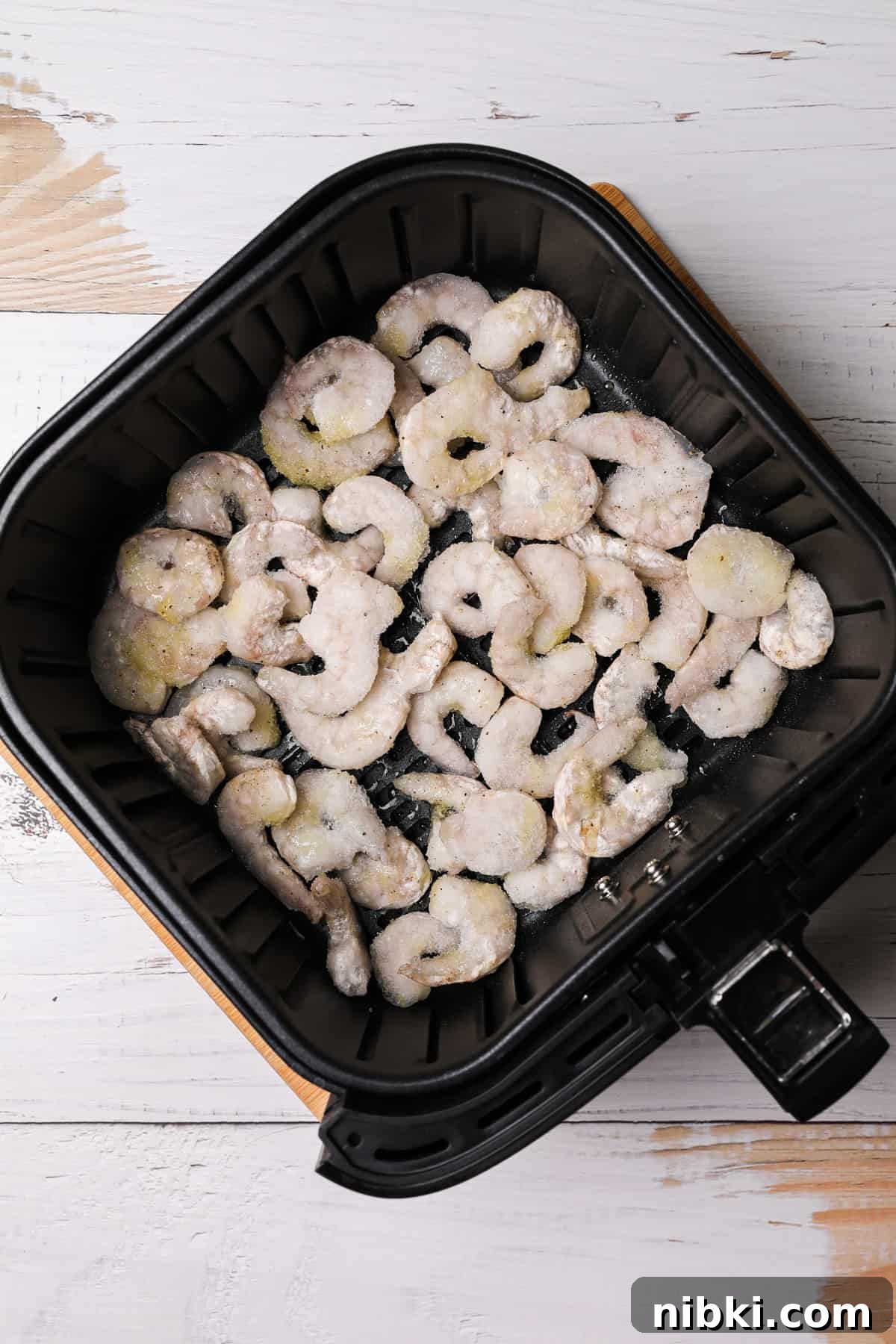How to Cook Crispy Frozen Shrimp in the Air Fryer 4 frozen uncooked shrimp in an air fryer basket
