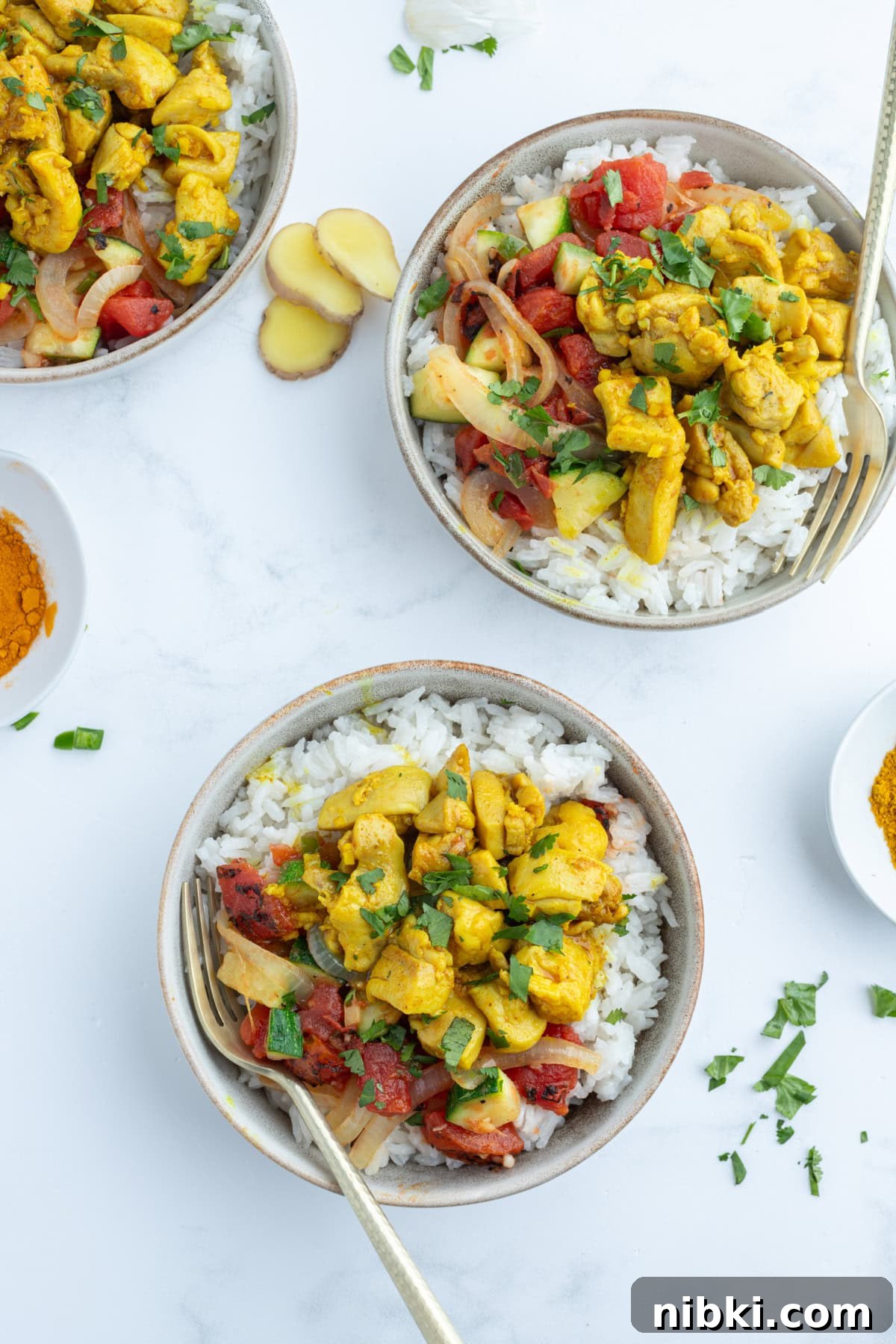 Chicken curry bowls with coconut rice, spiced chicken and a flavorful tomato mixture. Cozy, balanced and perfect for dinner! three chicken curry bowls