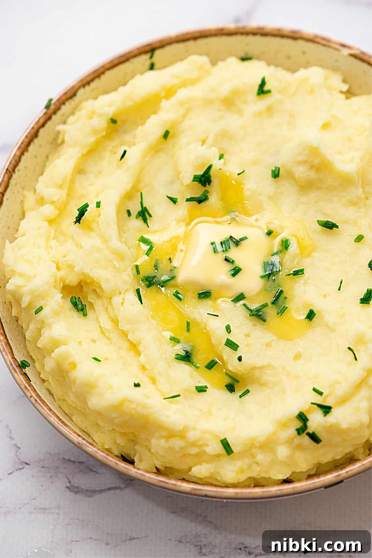 Homemade Mashed Potatoes Bowl of Yukon Gold Mashed Potatoes topped with chives.