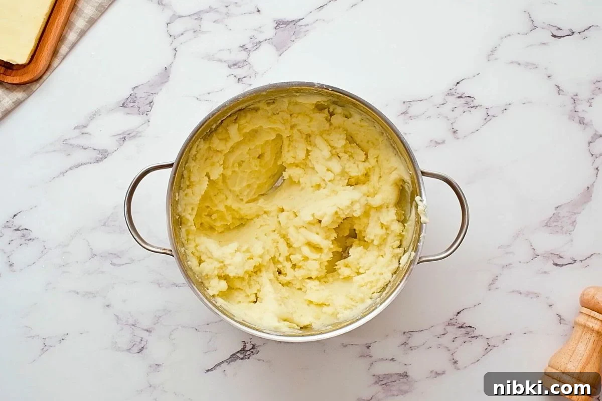 Yukon Gold Mashed Potatoes Pan with butter, milk, and sour cream folded into mashed potatoes for light and fluffy mashed potatoes.