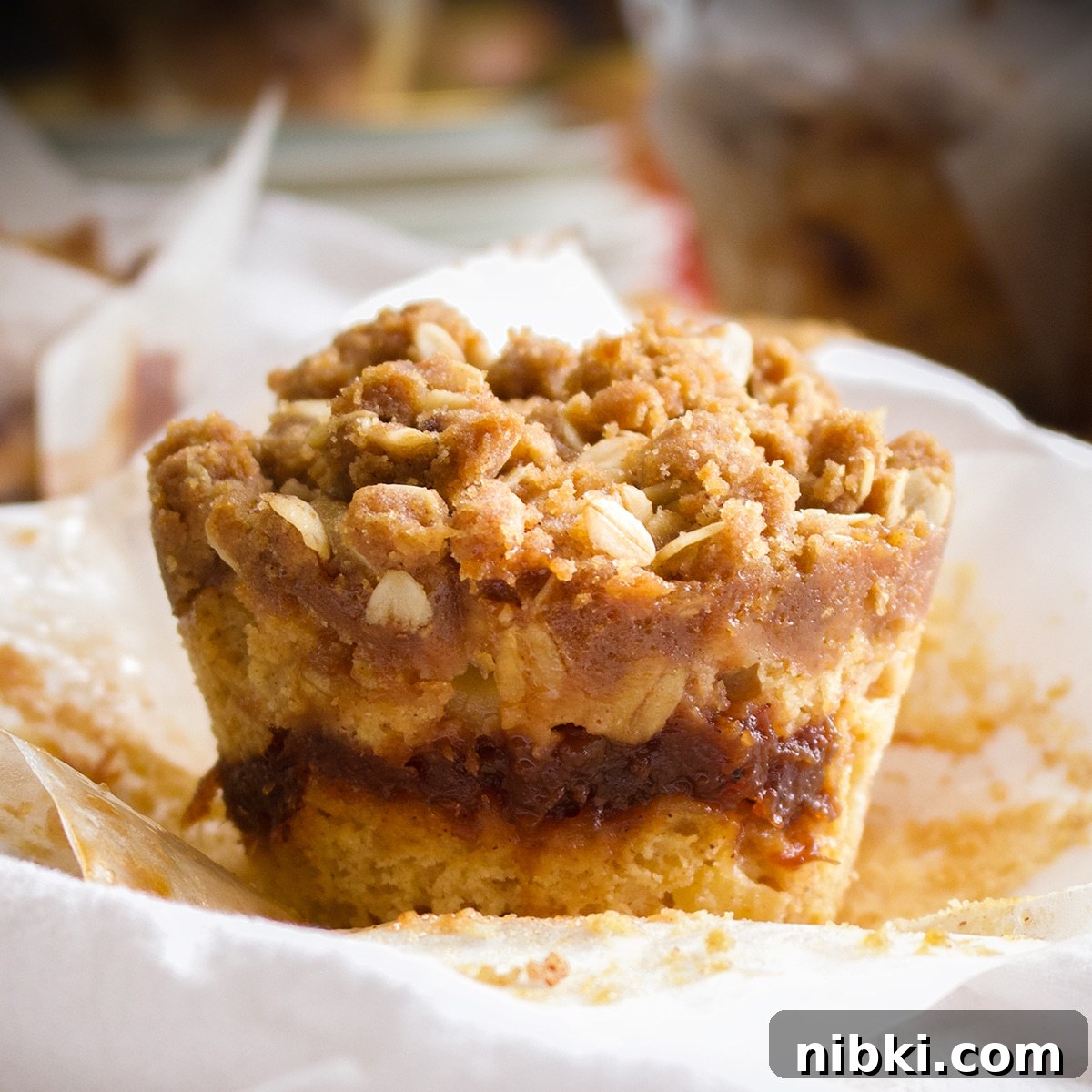 A freshly baked apple butter muffin on a white plate.