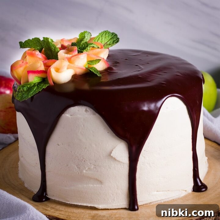 A 3-layer apple cider cake that's been iced with apple cider buttercream. covered with chocolate ganache, and decorated with apple roses.