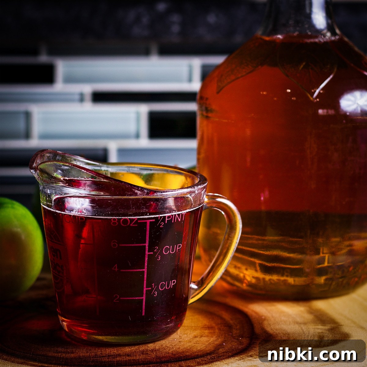 Spiced Apple Cider Cake with Cider Buttercream 6 A glass measuring cup filled with apple cider that's been reduced into a thick syrup.