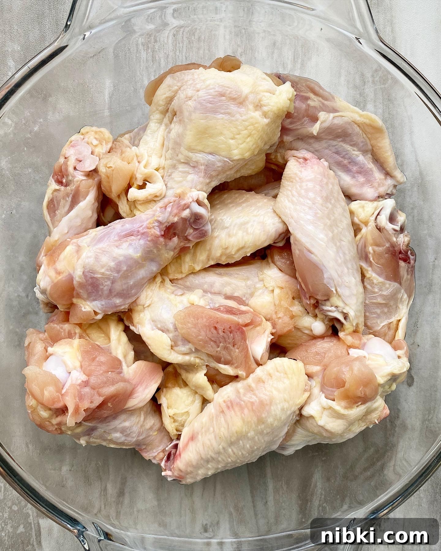 Crispy Marinated Chicken Wings in the Air Fryer 3 close up overhead shot of raw party chicken wings in a clear bowl