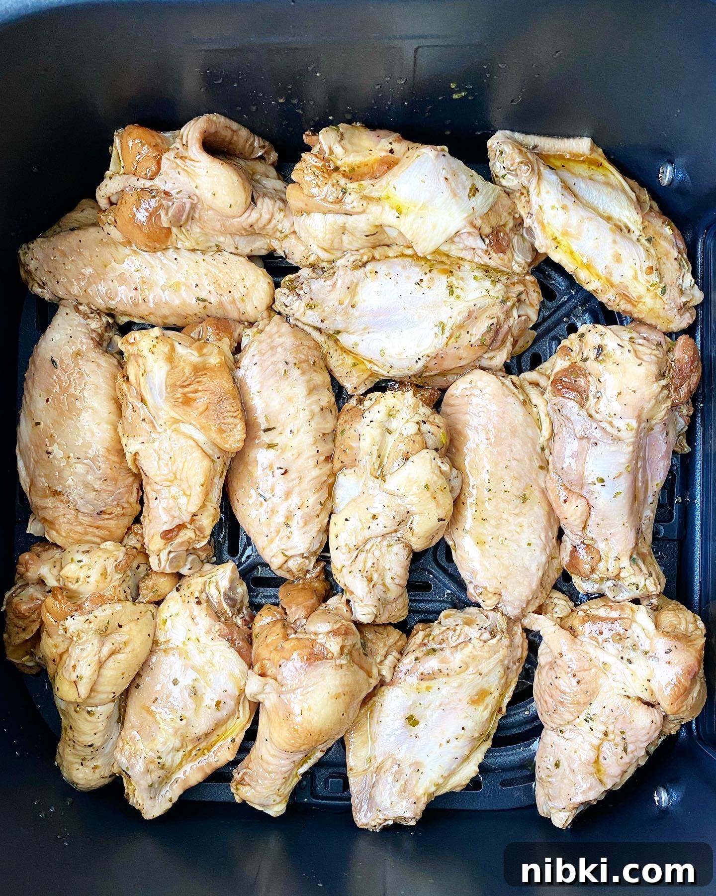 Crispy Marinated Chicken Wings in the Air Fryer 5 overhead shot of raw, uncooked marinated chicken wings in the air fryer basket