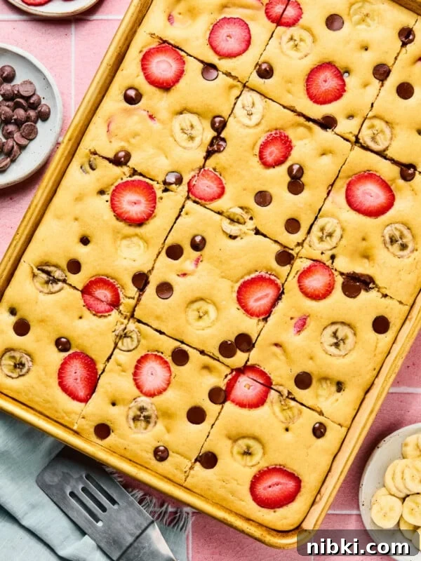 The baked sheet pan pancakes in the sheet pan cut into 12 slices.