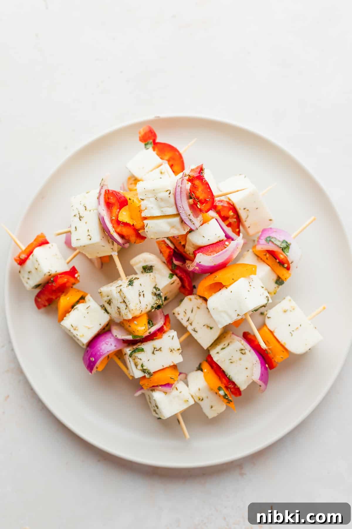 These sweet and savory Grilled Halloumi Skewers bring together deliciously marinated halloumi and veggies for a delightfully bright summer dish. prepared halloumi skewers ready to be grilled