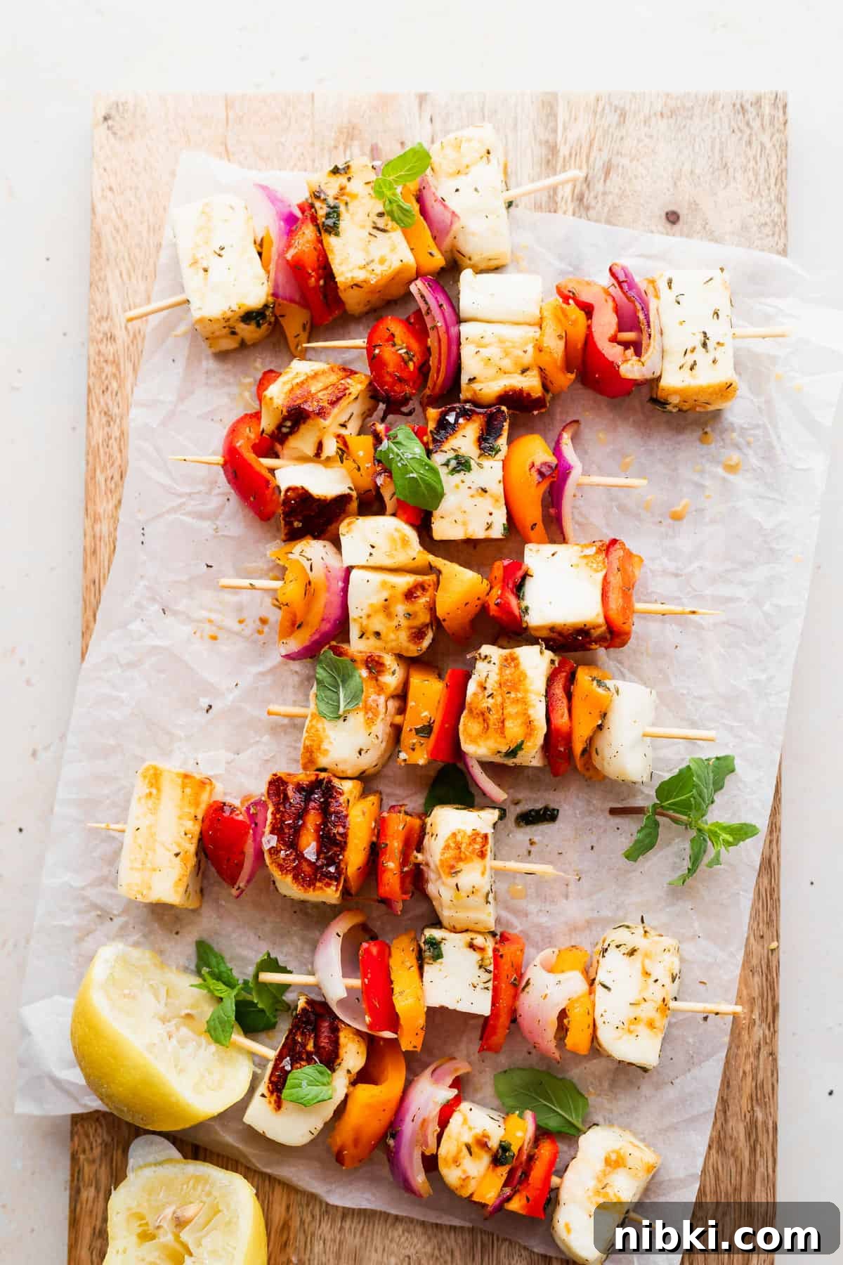 These sweet and savory Grilled Halloumi Skewers bring together deliciously marinated halloumi and veggies for a delightfully bright summer dish. grilled halloumi skewers on a cutting board, ready to be served