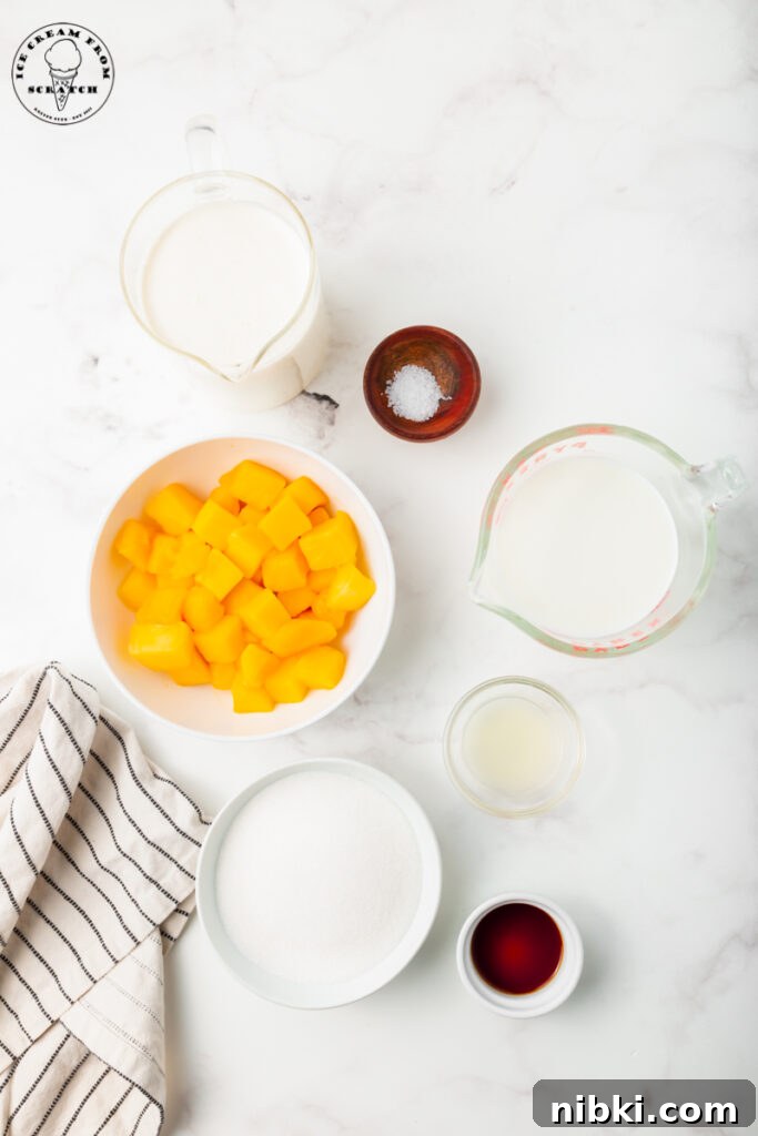 Homemade Mango Ice Cream Recipe 2 Ingredients for homemade mango ice cream on a marble countertop all in separate bowls.