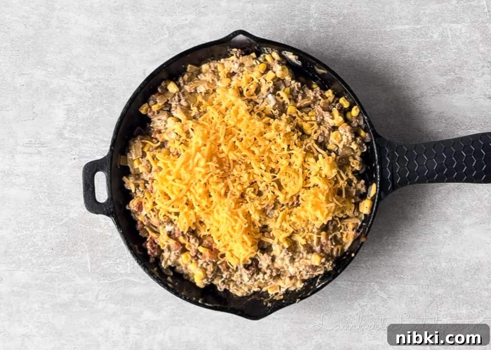 added cheese to the ground beef mixture in the cast iron skillet.