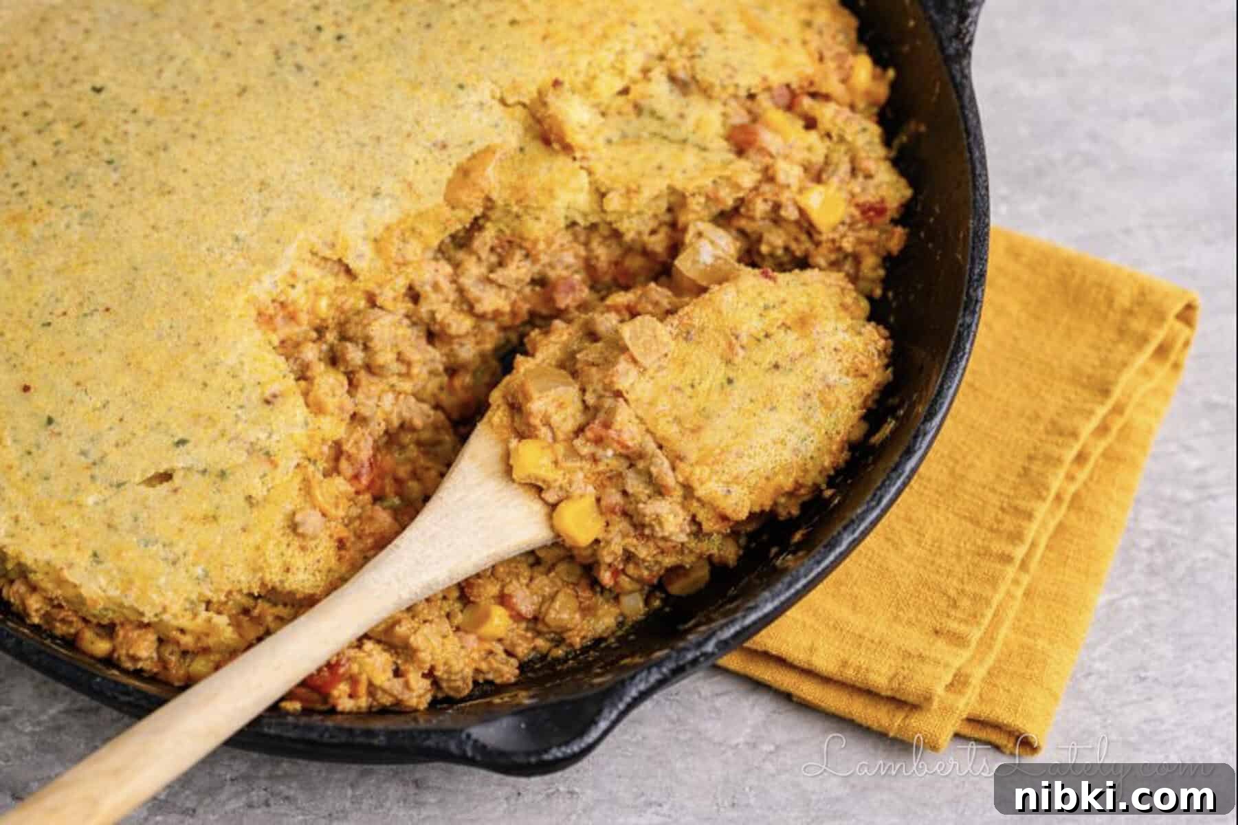 spoon in a cowboy casserole in a cast iron skillet.