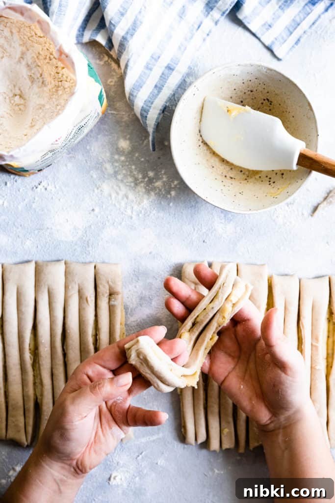 top view of a person holding a strip of dough