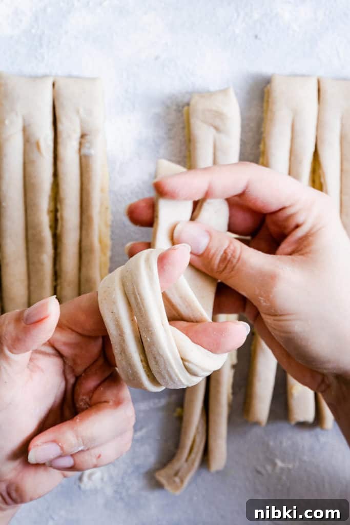close up of a person's hands shaping the dough into knot