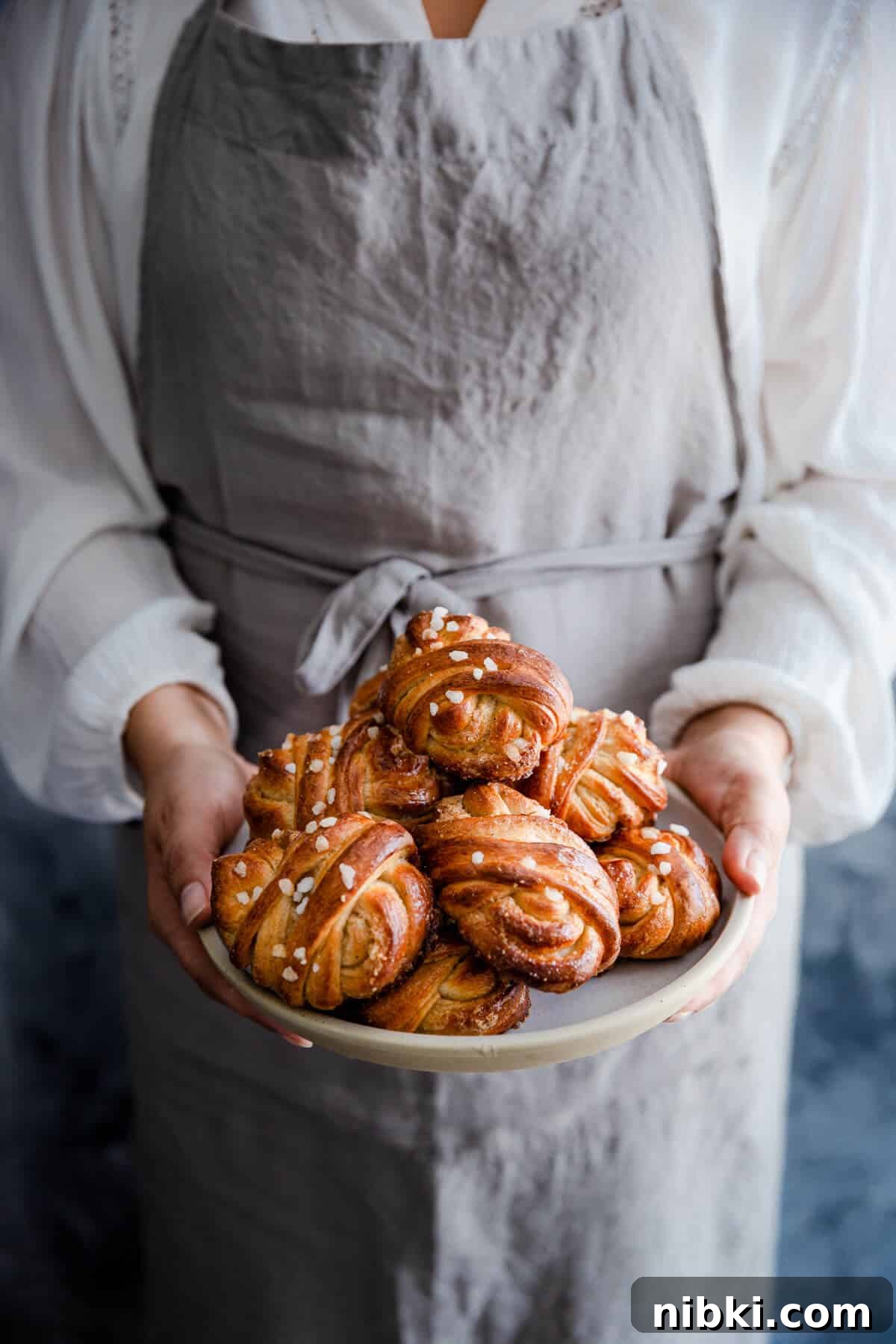 straight ahead shot of a person holding a plate with buns