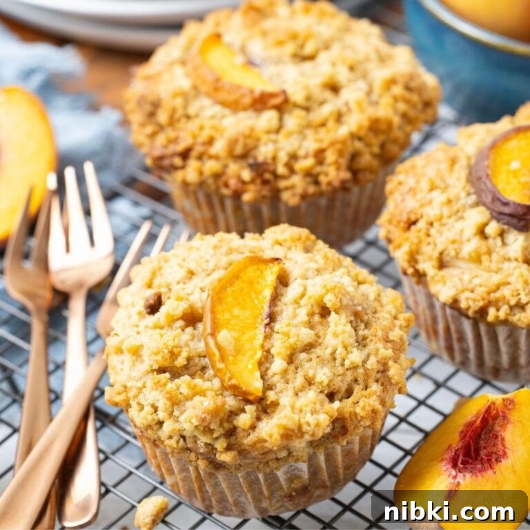 Sourdough Peach Cobbler Muffins Recipe 11 Close up of a sourdough peach cobbler muffin cooling on a wire rack.