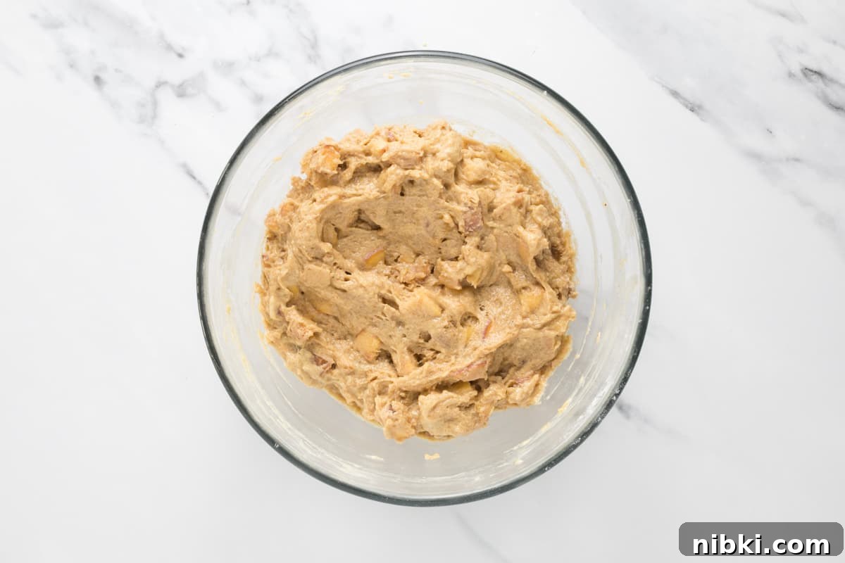 Sourdough Peach Cobbler Muffins Recipe 7 Sourdough peach cobbler muffin dough in a bowl ready to be added to muffin cups.