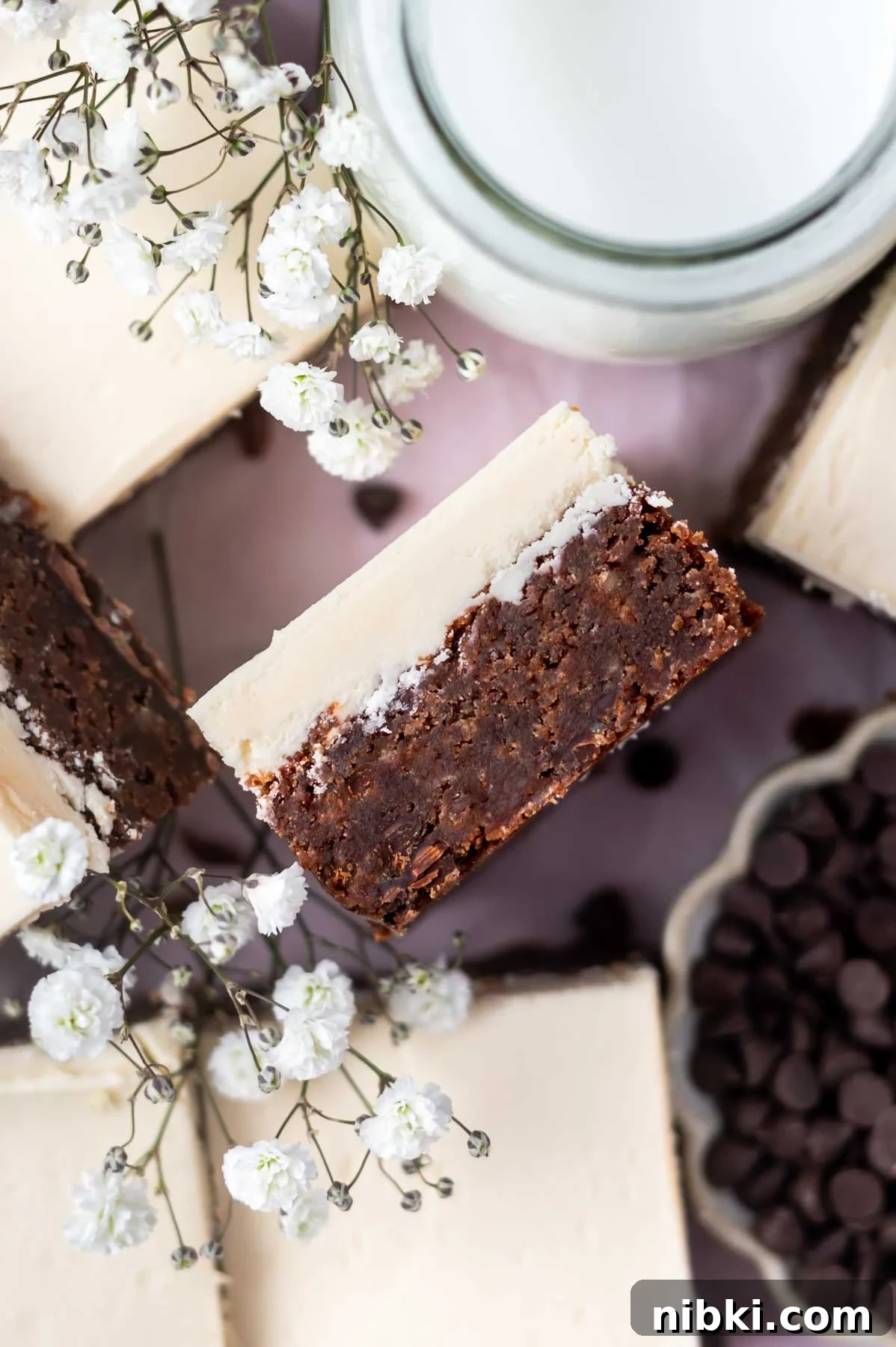 Fudgy Irish Cream Brownies Recipe 2 overhead look at the inside of an Irish cream brownie with frosting with fresh white flowers and a glass of milk nearby