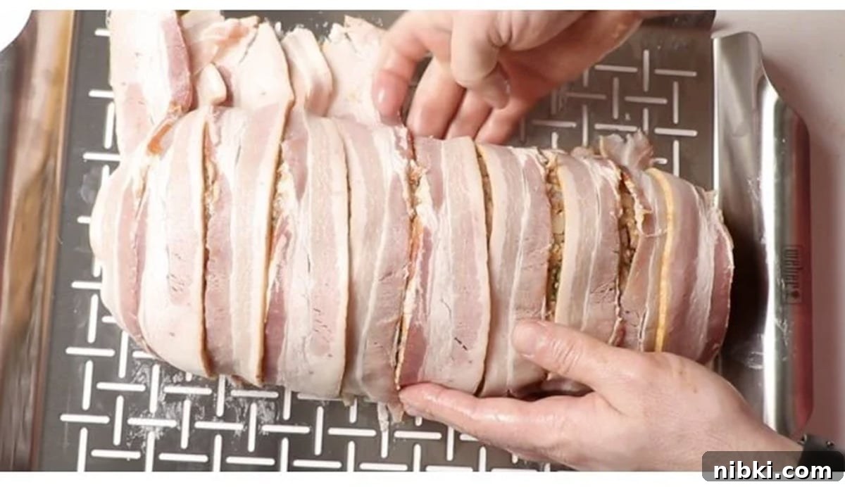 Smoked Meatloaf Recipe with Brown Sugar Glaze 11 Person wrapping stuffed meatloaf with bacon and putting on a grill.