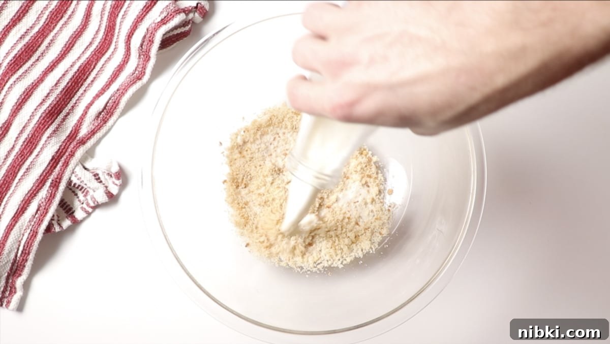 Smoked Meatloaf Recipe with Brown Sugar Glaze 6 Person pouring milk into the breadcrumbs.