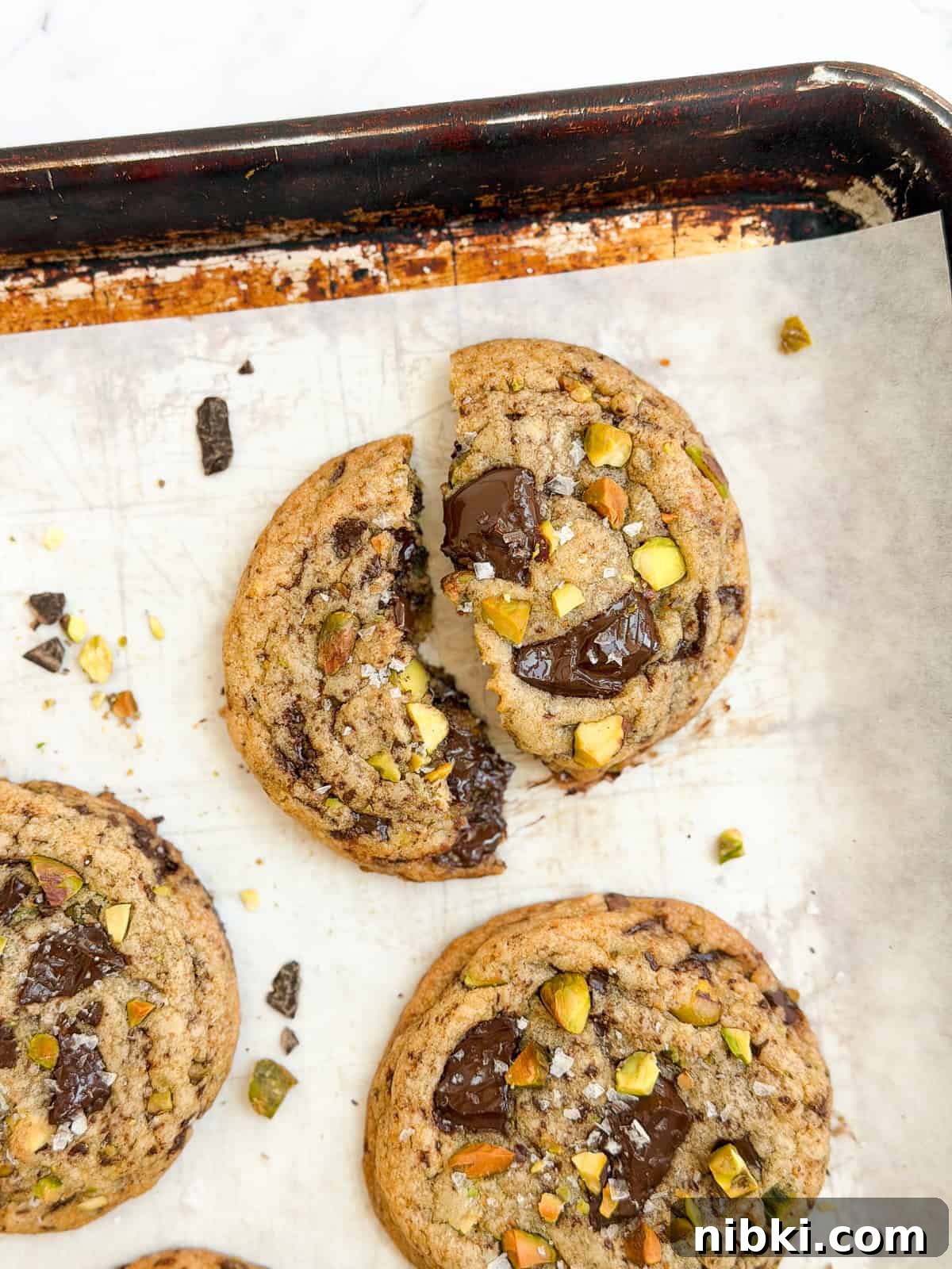 Chewy Pistachio Chocolate Chip Cookies Recipe 12 a broken cookie showing the melty chocolate.