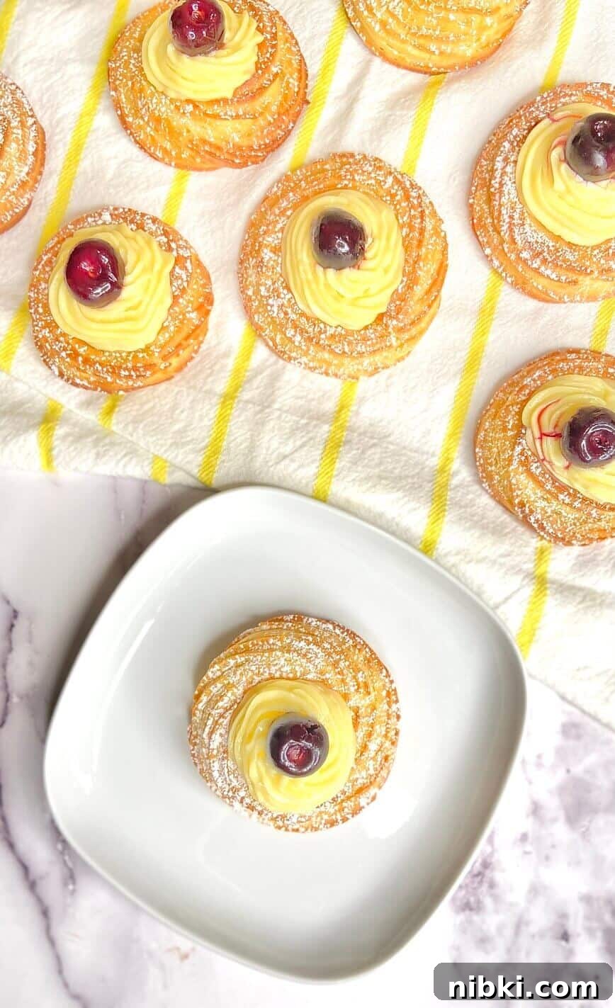 Zeppole di San Giuseppe: Classic St. Joseph's Pastry Recipe 4 Pastry finished with powdered sugar, served on a small white plate.