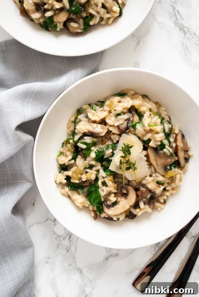 Instant Pot Creamy Mushroom and Spinach Risotto 3 a bowl of mushroom and spinach risotto on a table next to a napkin and cutlery