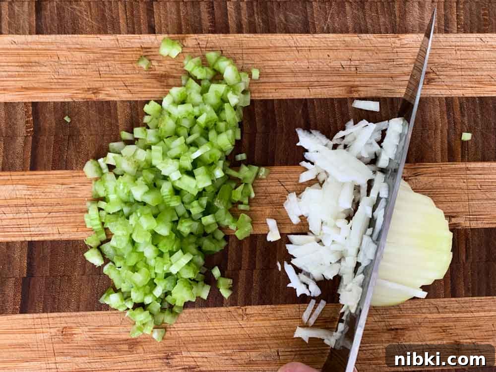 Instant Pot Creamy Mushroom and Spinach Risotto 4 A cutting board with finely diced celery and onion on it.