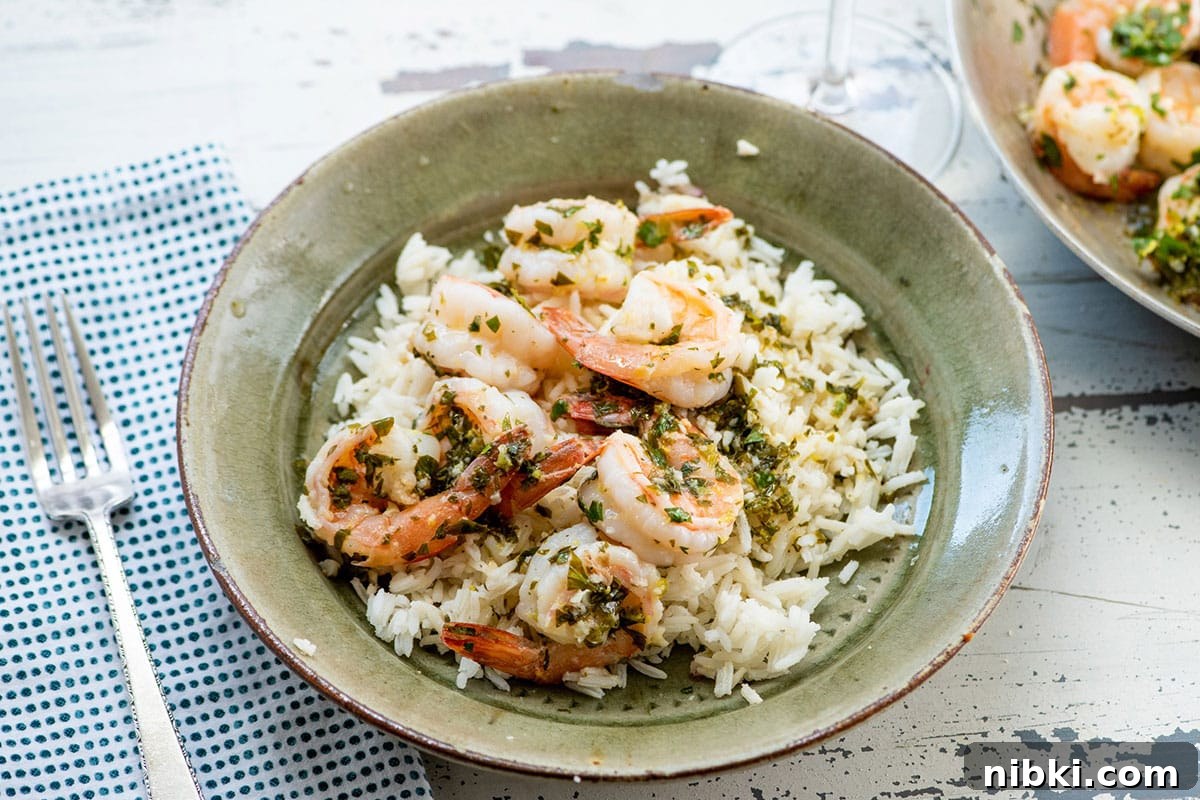 How to Reheat Rice Without Drying It Out 8 Green rice bowl with lemon shrimp on table.