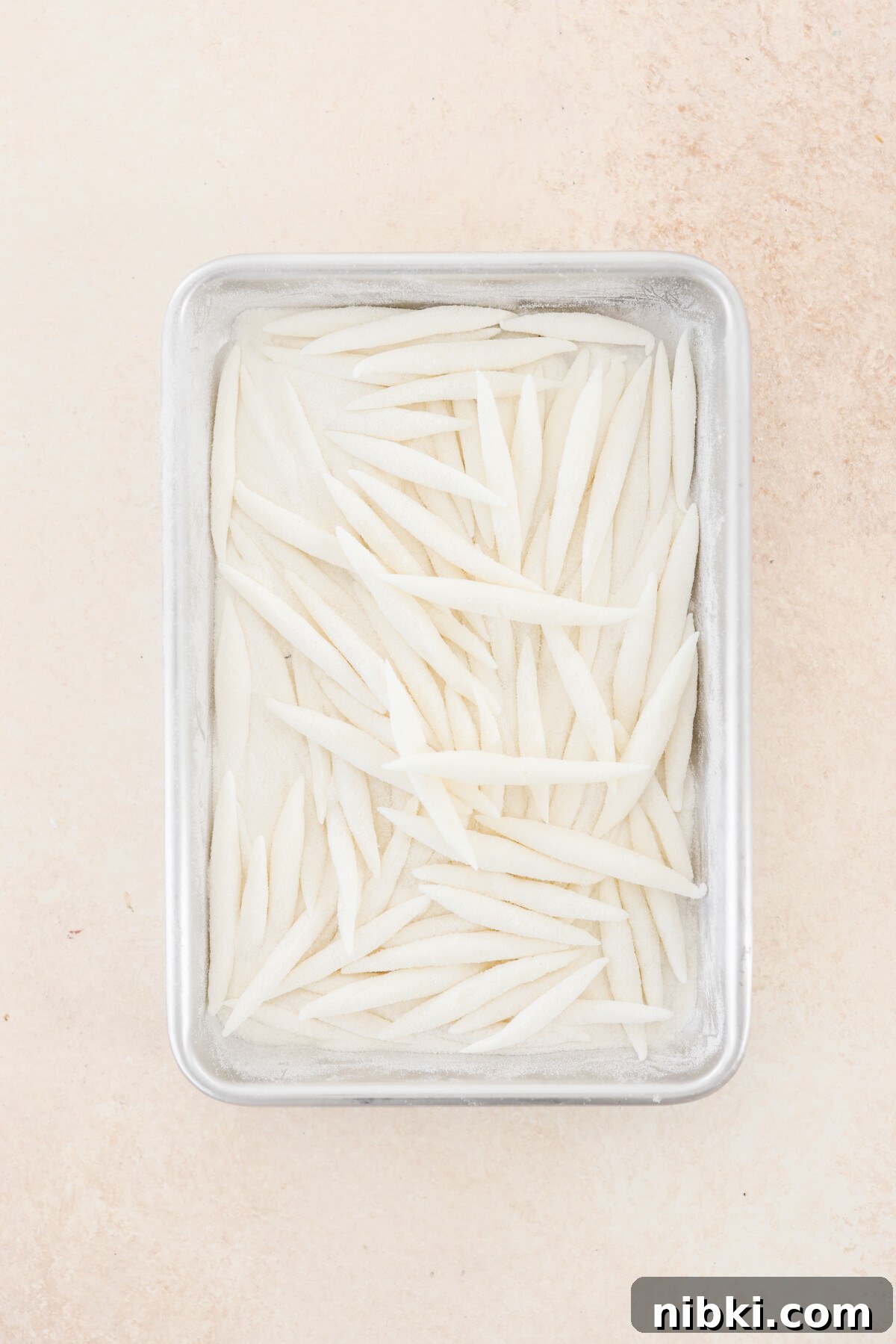 silver pin noodles on a baking tray