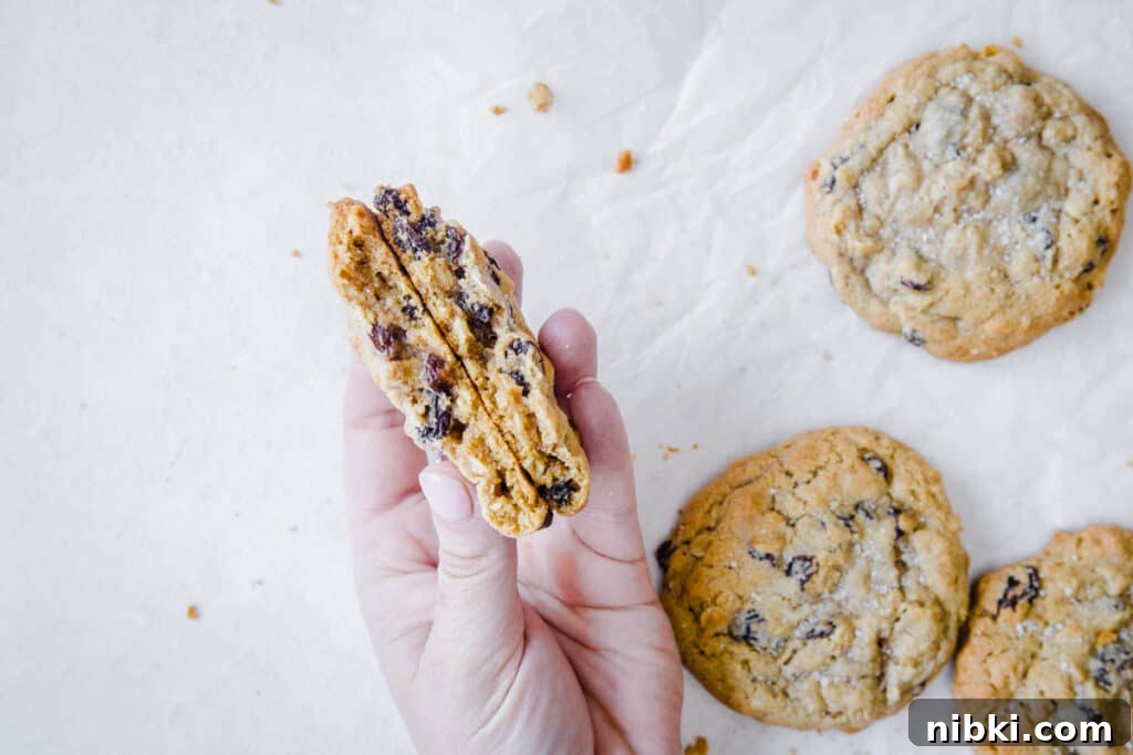 Classic Chewy Gluten-Free Oatmeal Raisin Cookies Recipe 9 hand holding cookies on a white background
