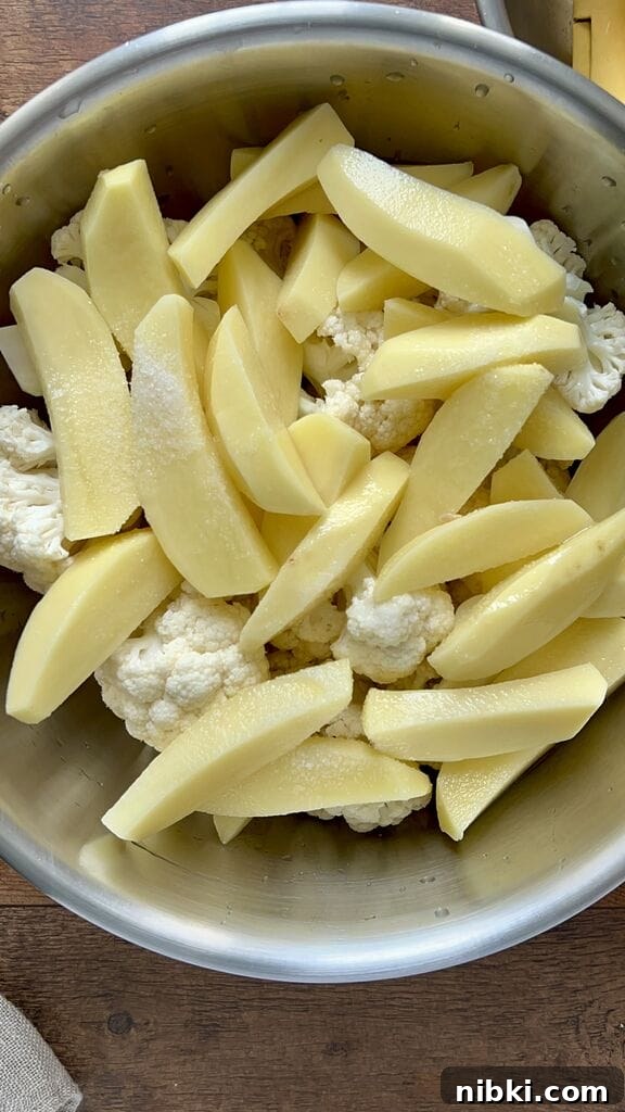 Adding salt to the potatoes and cauliflower.