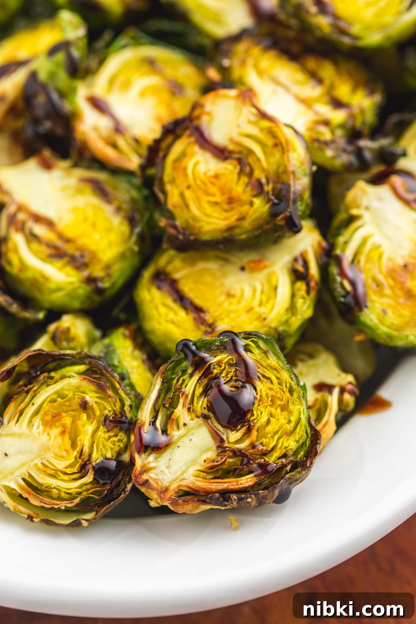 Crispy Air Fryer Brussels Sprouts with Garlic Parmesan 5 Close up shot of air fried brussels sprouts with a drizzle of balsamic glaze