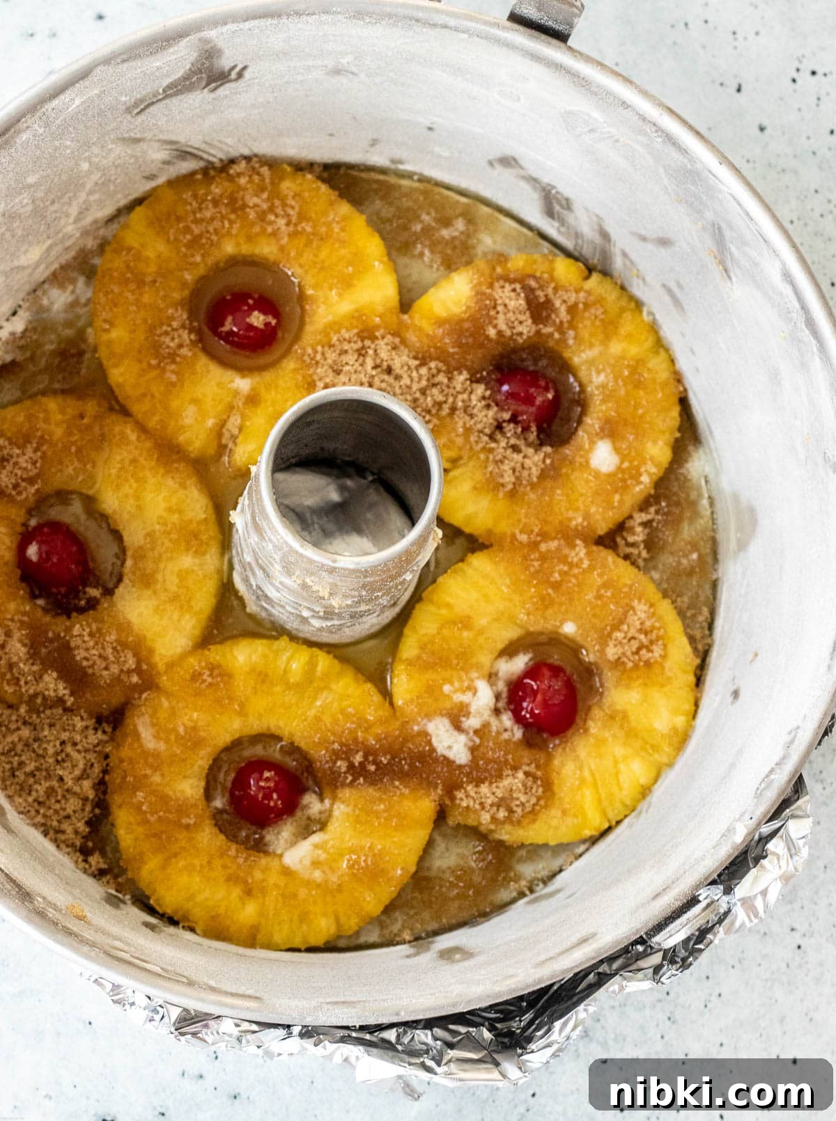 Moist Pineapple Upside-Down Pound Cake Recipe 7 Baking pan covered at the bottom with pineapple rings, maraschino cherries, brown sugar and melted butter.