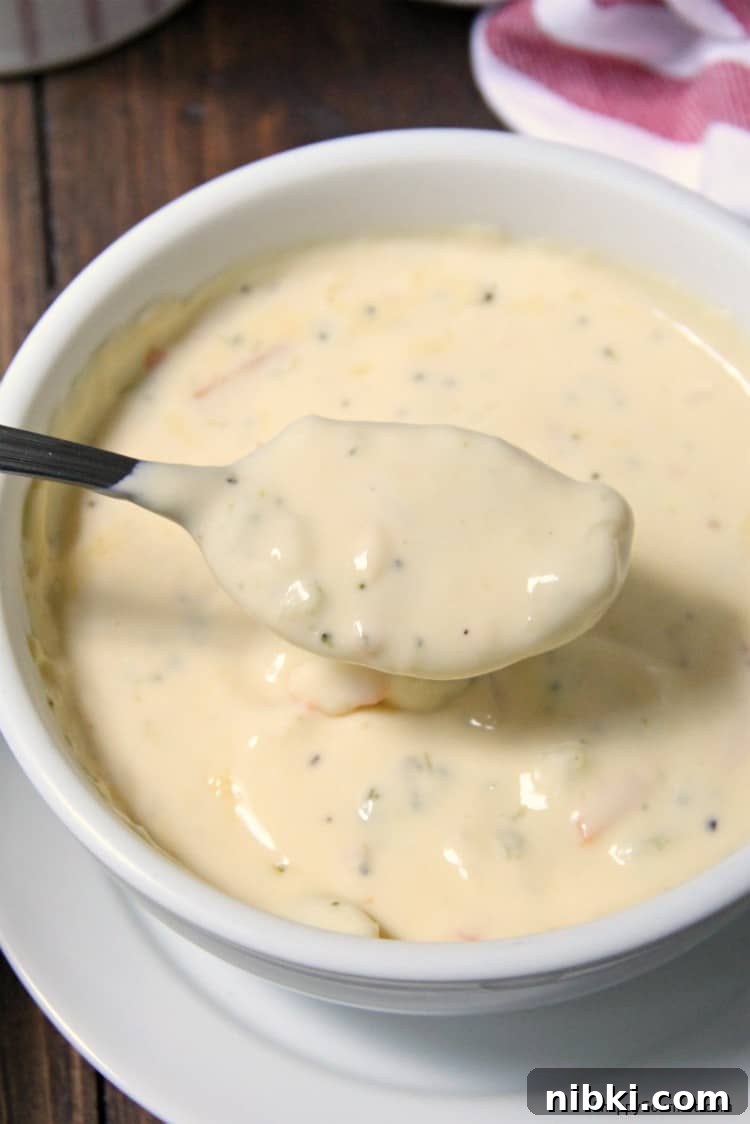 Broccoli Cheddar Soup recipe - easy soup with broccoli, carrots, and cheese Broccoli Cheddar Soup in white bowl with spoon