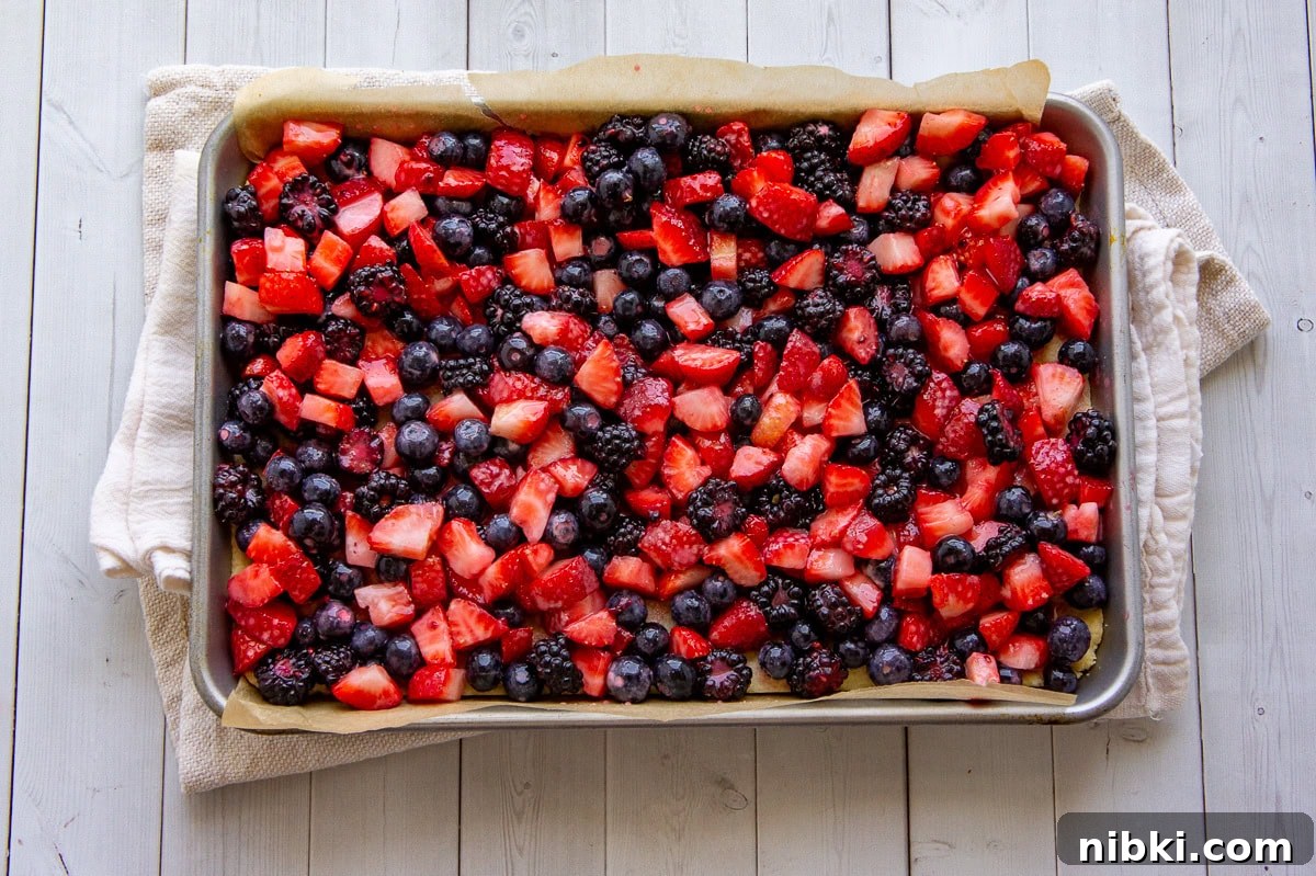 Mixed Berry Crumble Bars Recipe with Oat Streusel 6 Berries spread on a baking sheet