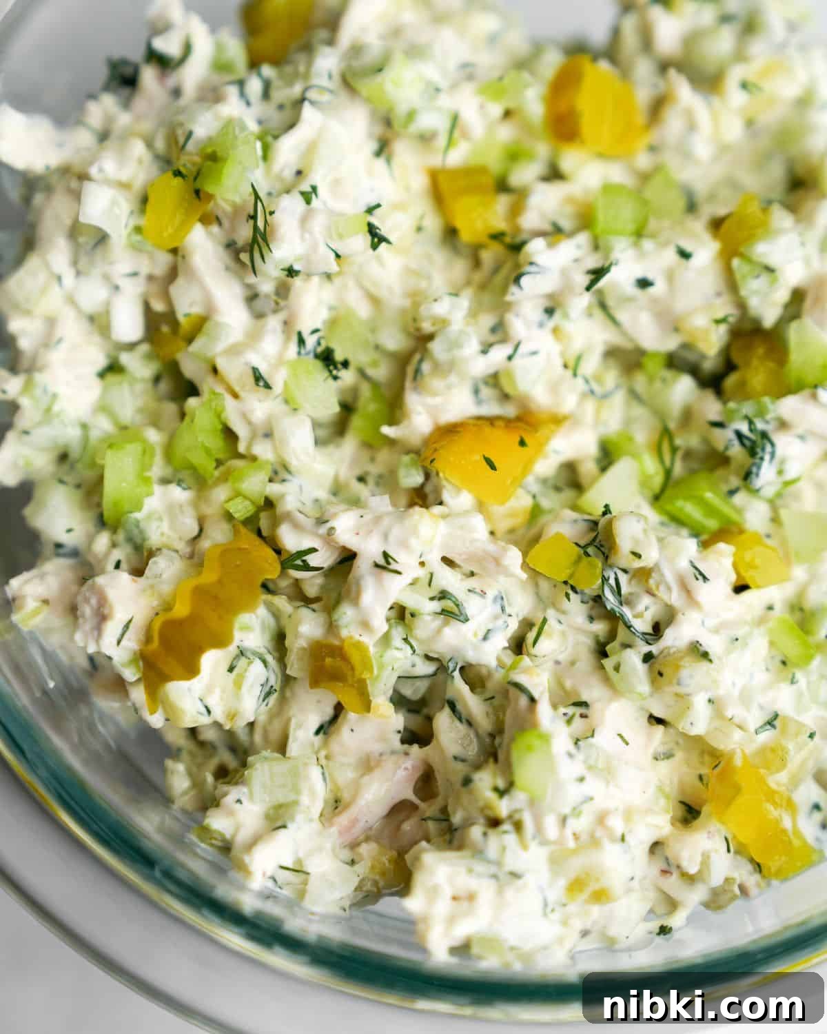 chicken salad in a bowl in chunks of pickles