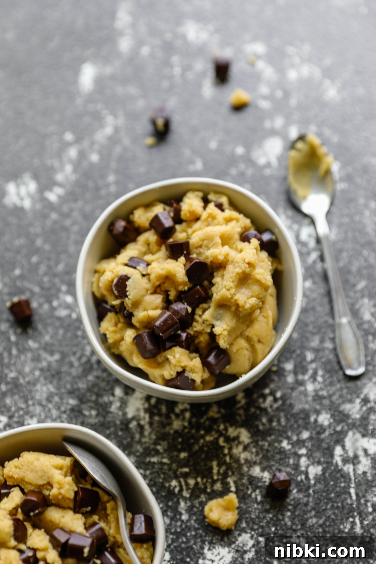 No-Bake Edible Vegan Cookie Dough Recipe 6 Edible Vegan Cookie Dough served in bowls with a cookie scoop and a bowl of chocolate Gems
