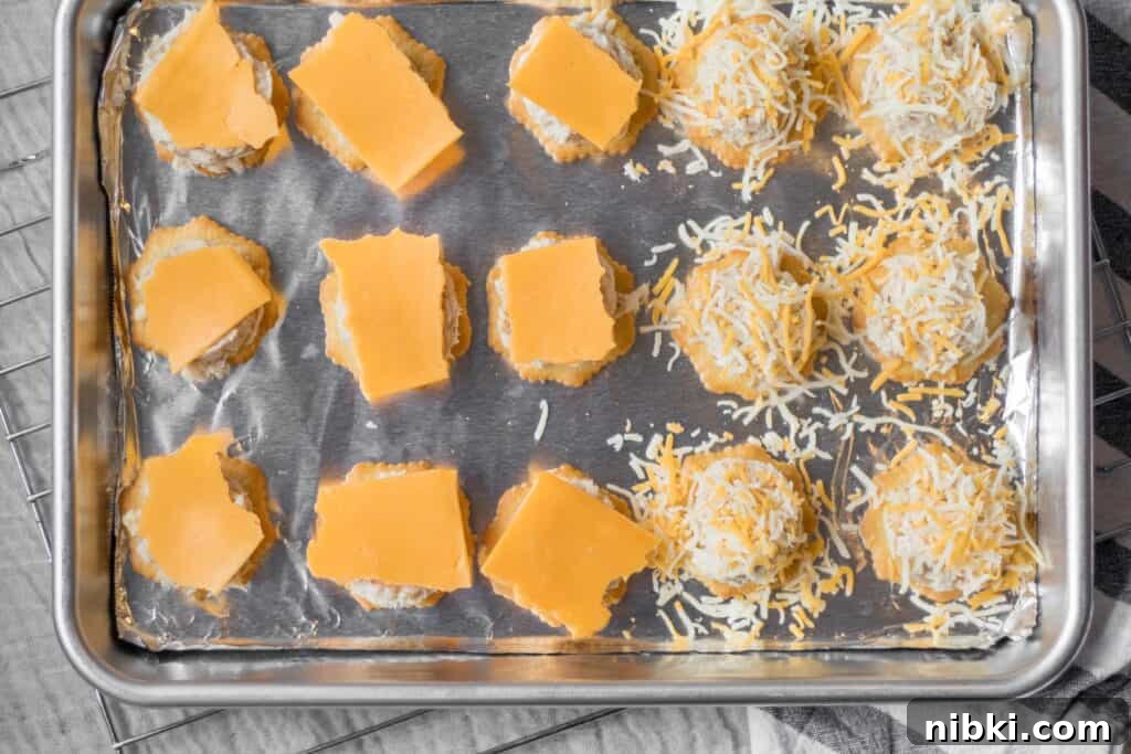 Mini Tuna Melt Bites on Crispy Crackers 5 tuna melts with cheese on top ready for the oven