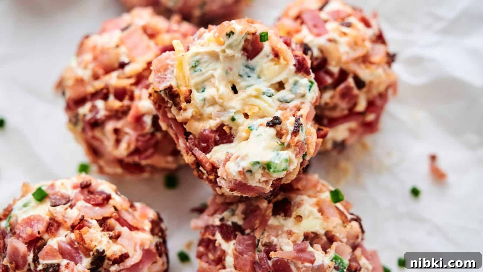 33 Christmas Potluck Recipes to Bring December Magic 15 Close-up of several Bacon Jalapeno Popper Cheese Balls wrapped in bacon, stuffed with cheese, and seasoned with herbs and spices, placed on crumpled parchment paper.