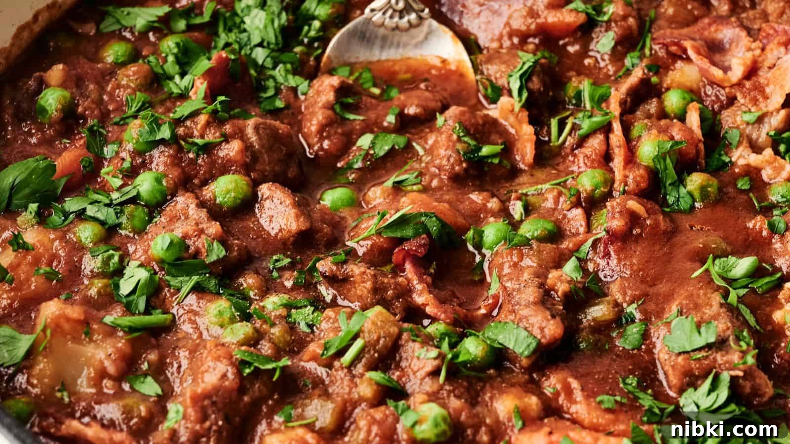 33 Christmas Potluck Recipes to Bring December Magic 17 A close-up of a beef stew with green peas and chopped parsley, showing a spoon partially submerged in the rich, red sauce.