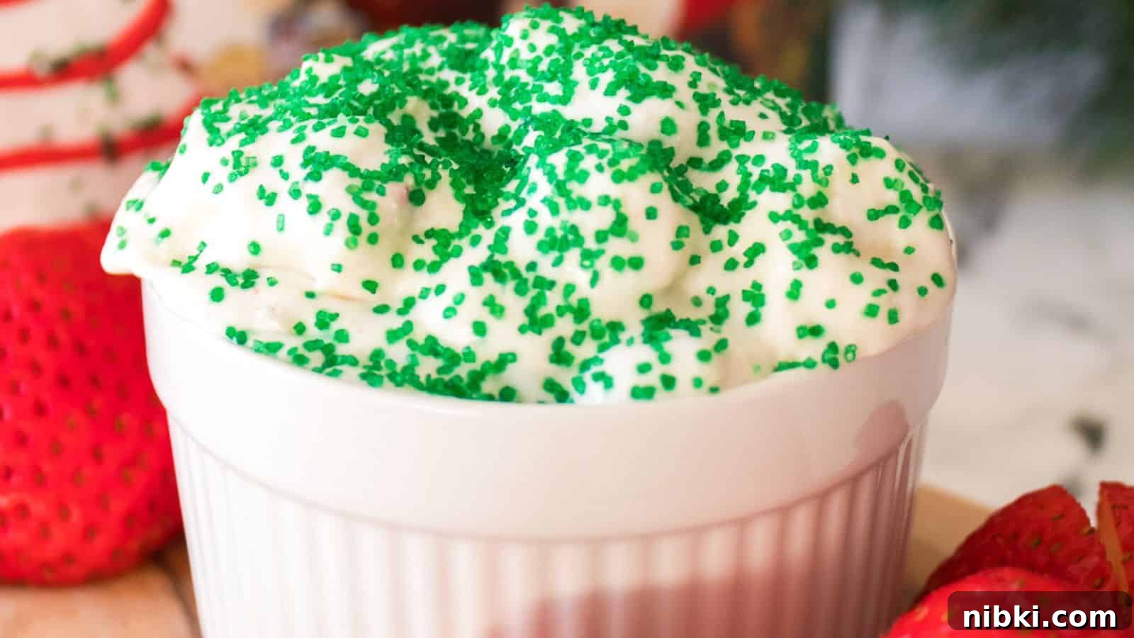 33 Christmas Potluck Recipes to Bring December Magic 20 A white bowl filled with whipped cream topped with green sprinkles, surrounded by fresh strawberries.