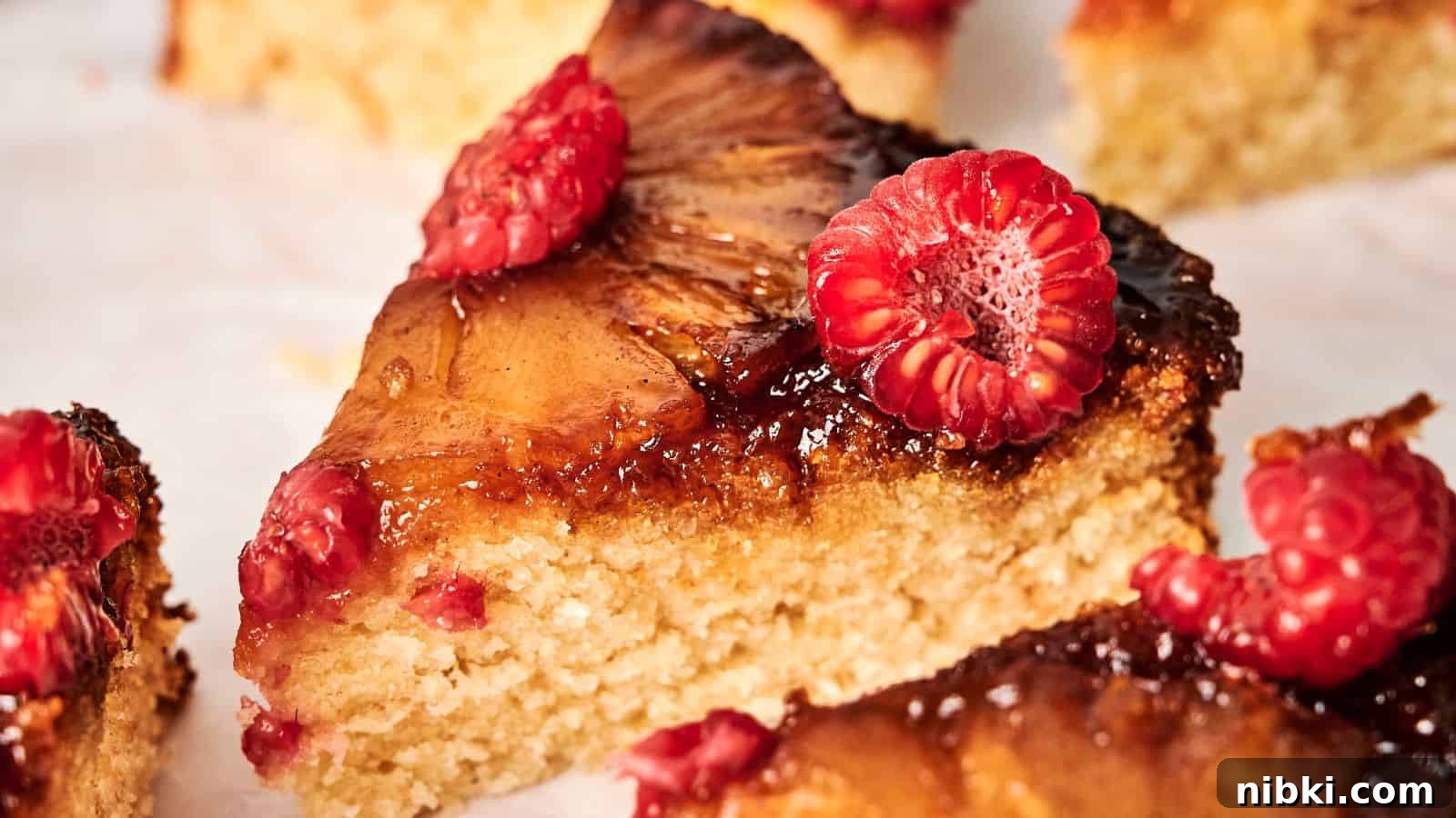 33 Christmas Potluck Recipes to Bring December Magic 21 A slice of pineapple cake topped with fresh raspberries on a white surface.