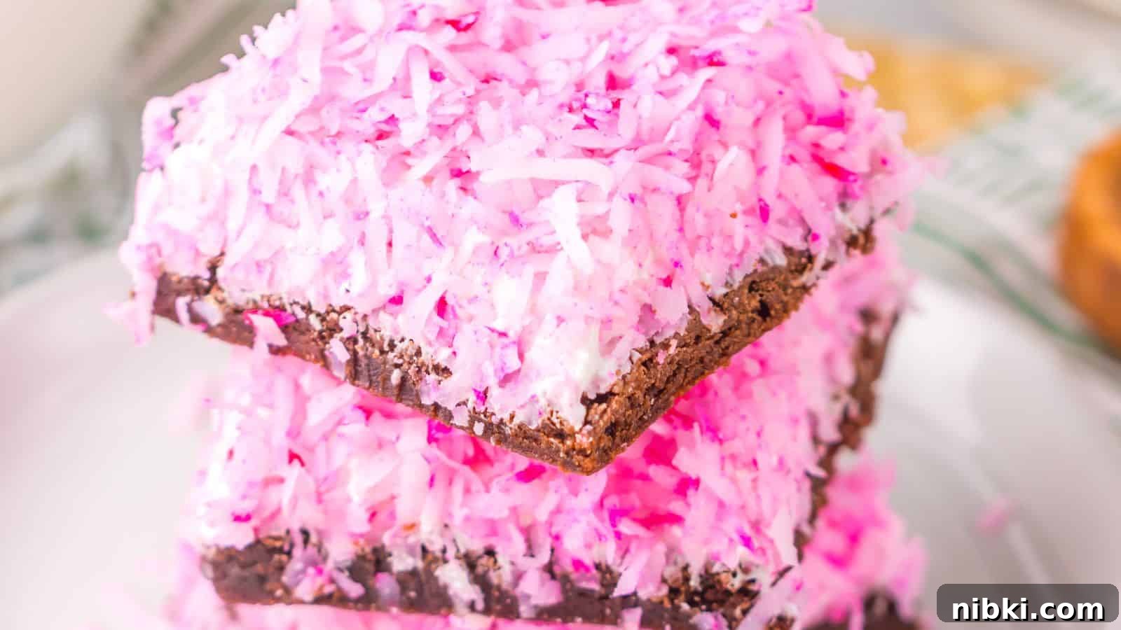 33 Christmas Potluck Recipes to Bring December Magic 26 Three stacked slices of chocolate coconut candy, reminiscent of Pink Snoball Brownies, topped with pink shredded coconut.
