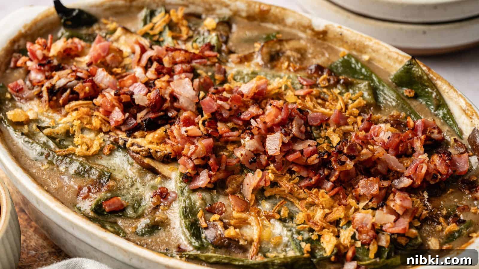 33 Christmas Potluck Recipes to Bring December Magic 33 A baked casserole topped with chopped bacon, crispy onions, and melted cheese, featuring visible green peppers and a creamy sauce.