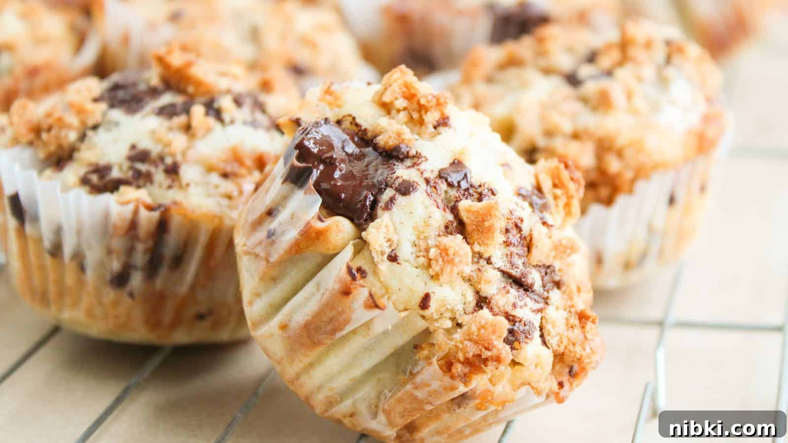 33 Christmas Potluck Recipes to Bring December Magic 8 Close-up of chocolate chip muffins with crumb topping in paper liners, cooling on a wire rack.
