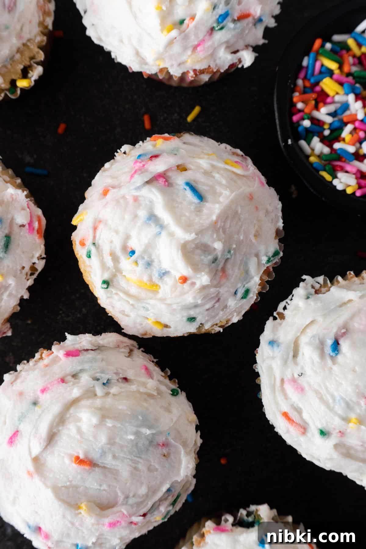 funfettie birthday cupcakes on black background.