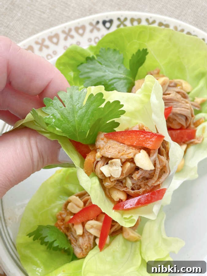 taking a bite of slow cooker satay pork