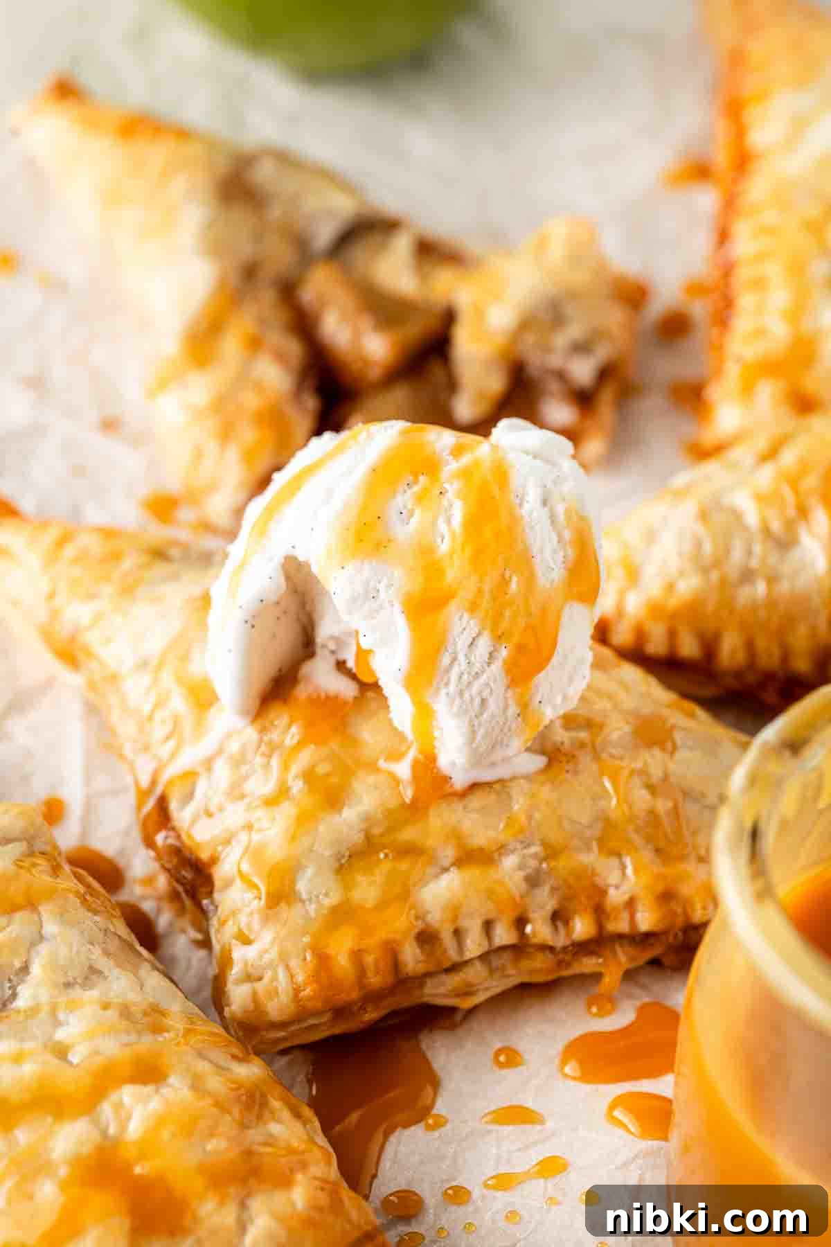 Apple turnovers with ice cream and caramel sauce.